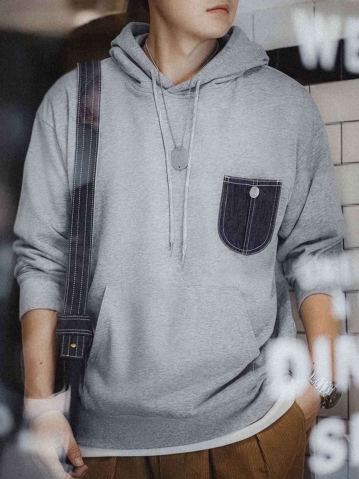 詳細画像:
「霜降り模様のコットン感ストレッチニット生地と、白いステッチと刻印入り銅製ボタンをあしらったデニムポケットのディテールクローズアップ。パッチワークデザインがヴィンテージ感と立体感を強調。」
モデル画像:
「モデルがデニムポケット付き パッチワーク パーカーを着用し、スポーティーなヴィンテージスタイルを披露。ゆったりとしたルーズフィットのシルエットが、カジュアルシーンからスポーツスタイルまで幅広く対応。」