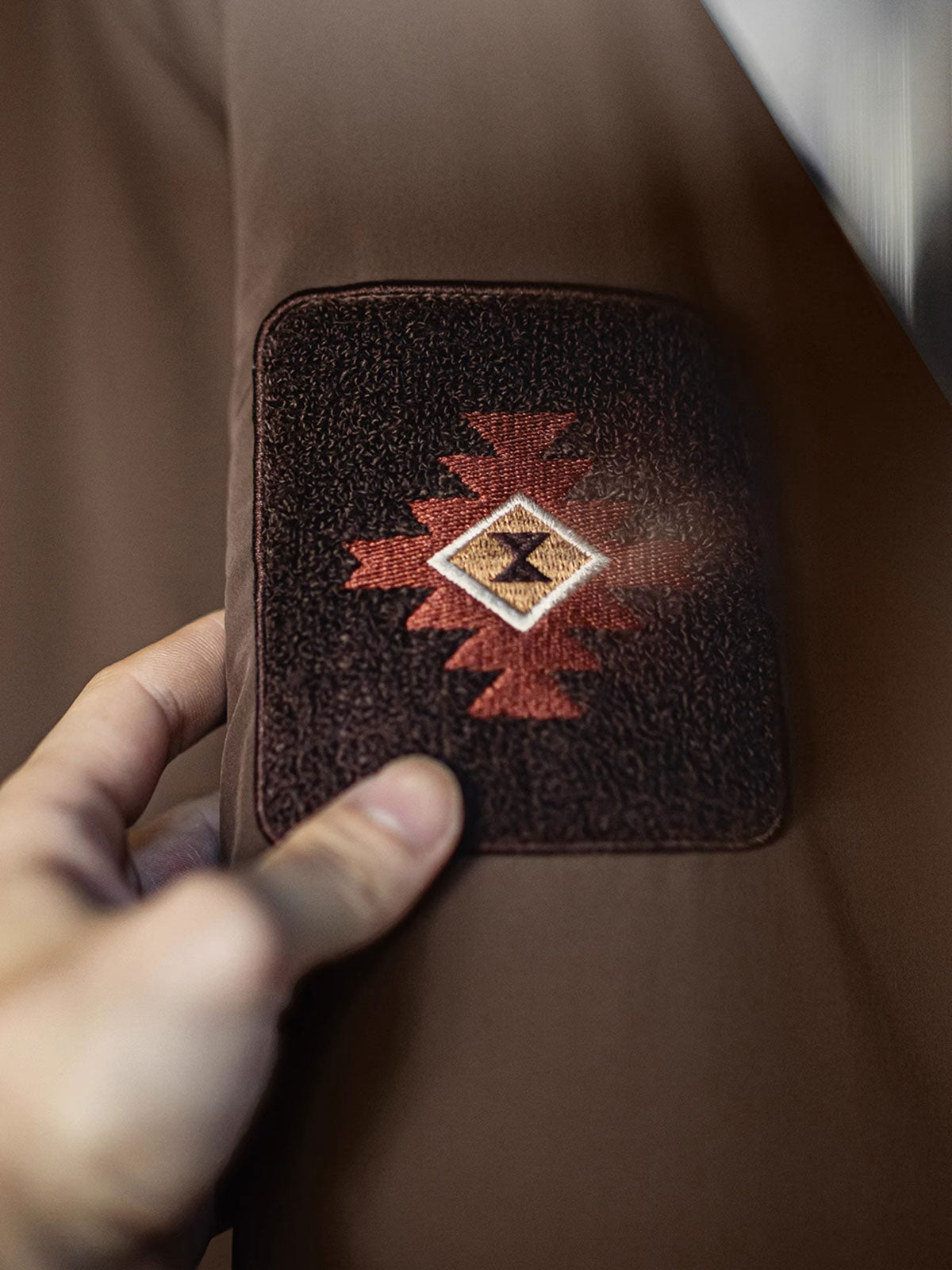 アームパッチとリブ袖の防風ディテールのクローズアップ