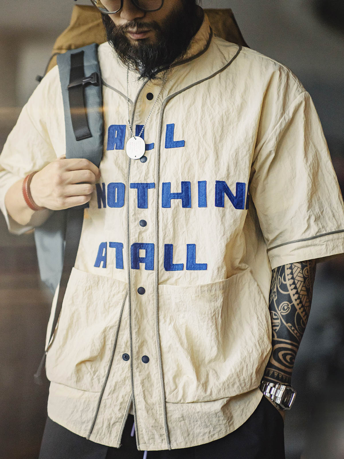 カーディガンのクラインブルーのフェルトアルファベットと大きな対称ポケットの詳細画像モデルがヴィンテージシワ感ベースボールカラーアルファベットショートスリーブカーディガンを着用している画像