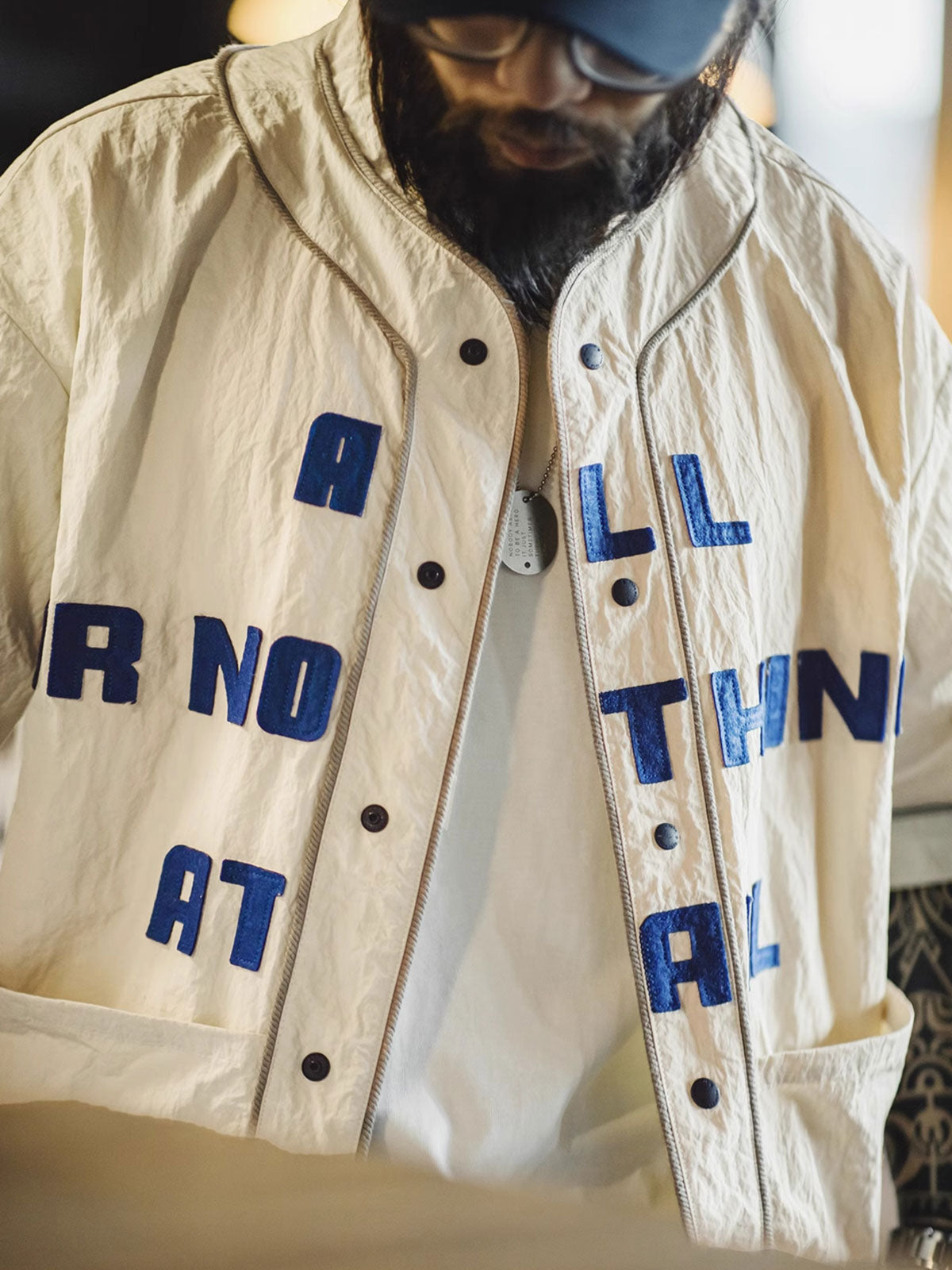 カーディガンのクラインブルーのフェルトアルファベットと大きな対称ポケットの詳細画像