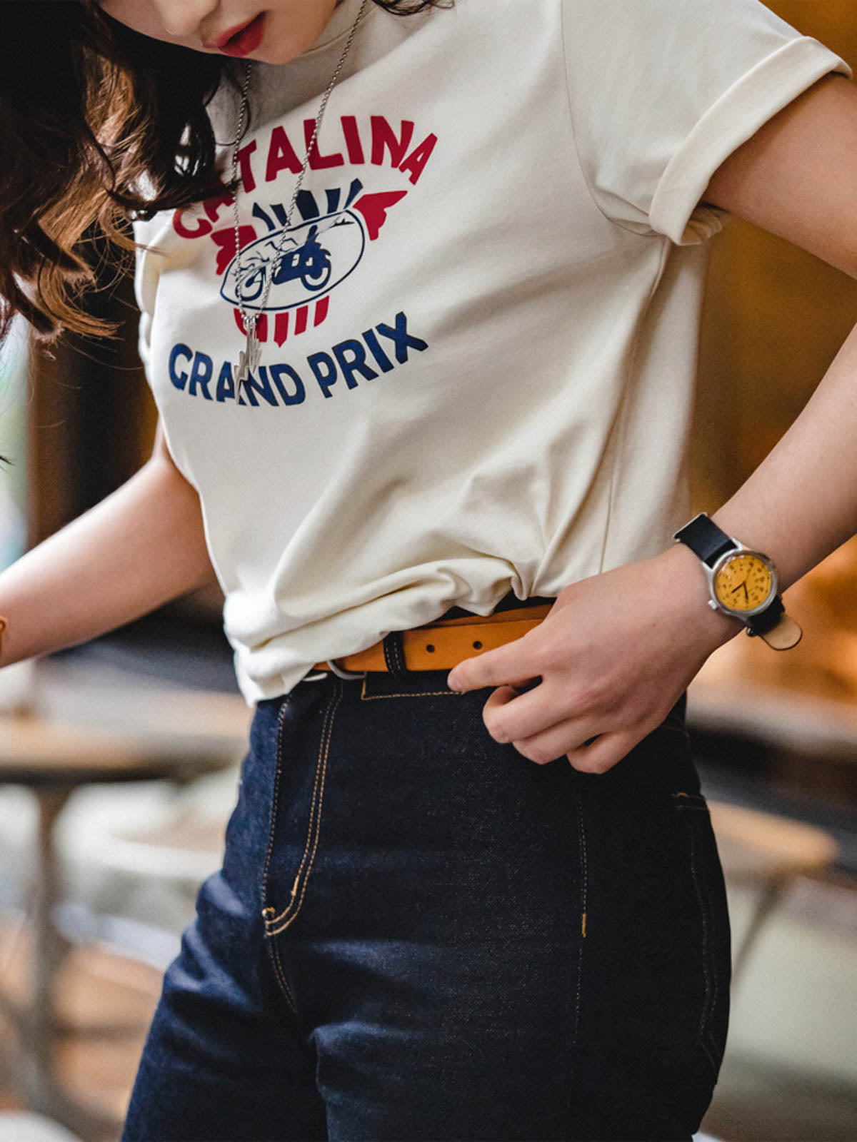 モデルがカタリナ・グランプリ モーターサイクルレースプリントTシャツを着用し、カジュアルスタイルを披露。