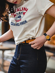 モデルがカタリナ・グランプリ モーターサイクルレースプリントTシャツを着用し、カジュアルスタイルを披露。