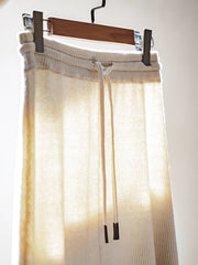 商品画像: レトロスタイルのベージュニットAラインスカート正面展示 詳細画像: ベージュニットAラインスカートの縦リブとウエストのドローストリング詳細 モデル画像: モデルがベージュニットAラインスカートを着用し、そのエレガントなスタイルを披露