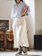 商品画像: レトロスタイルのベージュニットAラインスカート正面展示 詳細画像: ベージュニットAラインスカートの縦リブとウエストのドローストリング詳細 モデル画像: モデルがベージュニットAラインスカートを着用し、そのエレガントなスタイルを披露