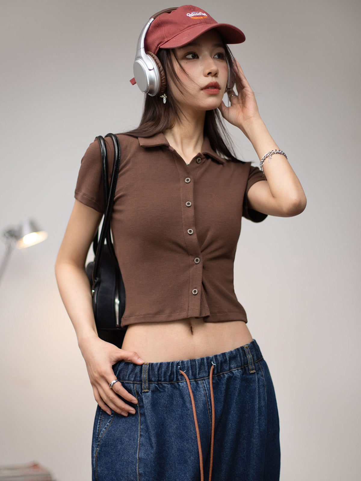 モデルがスタンドカラー ポロ ショートスリーブ ニットカーディガンを着用し、スタイルを全身で披露