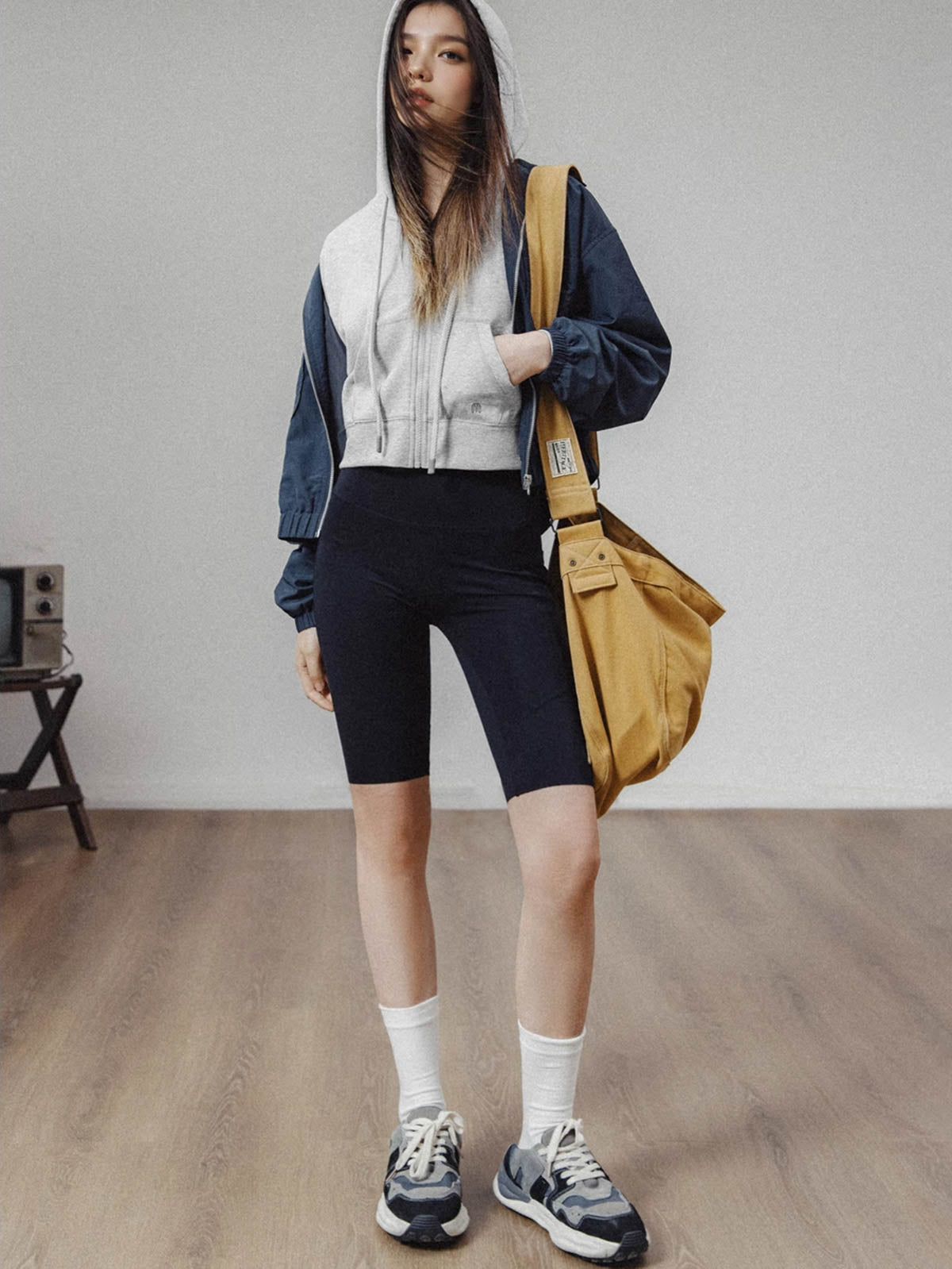 モデルがアメリカンストリートスタイルのグレーショート丈フーディージップアップを着用し、多様なスタイリングを披露