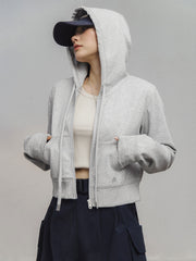 モデルがアメリカンストリートスタイルのグレーショート丈フーディージップアップを着用し、多様なスタイリングを披露