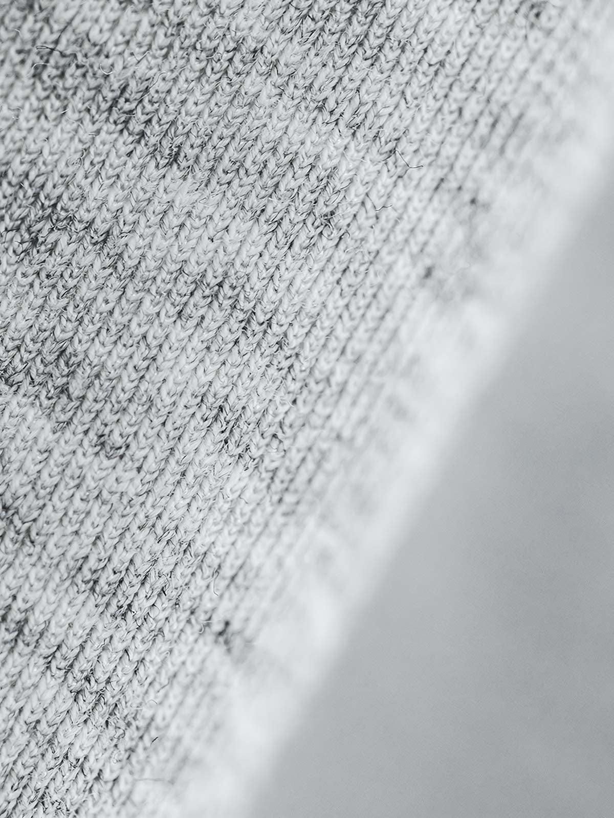 グレーショート丈フーディーのスノーフレークパターンとジッパーのディテール特写