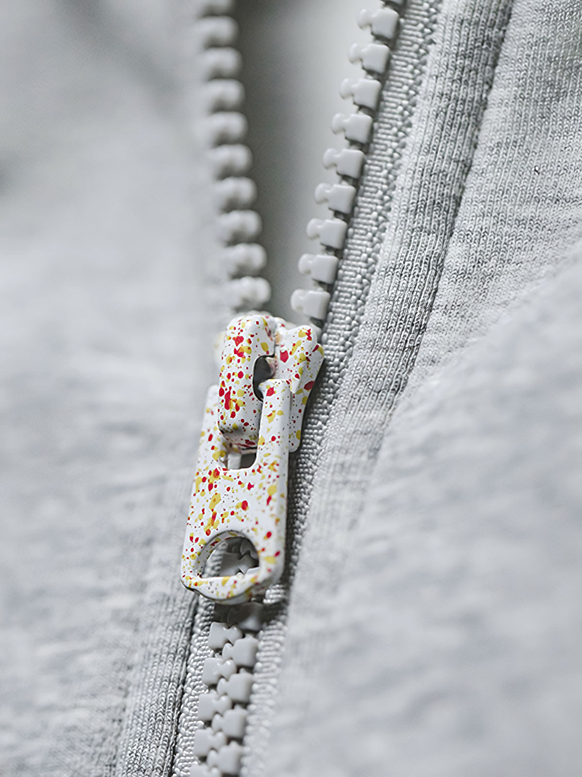 グレーショート丈フーディーのスノーフレークパターンとジッパーのディテール特写