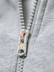 グレーショート丈フーディーのスノーフレークパターンとジッパーのディテール特写