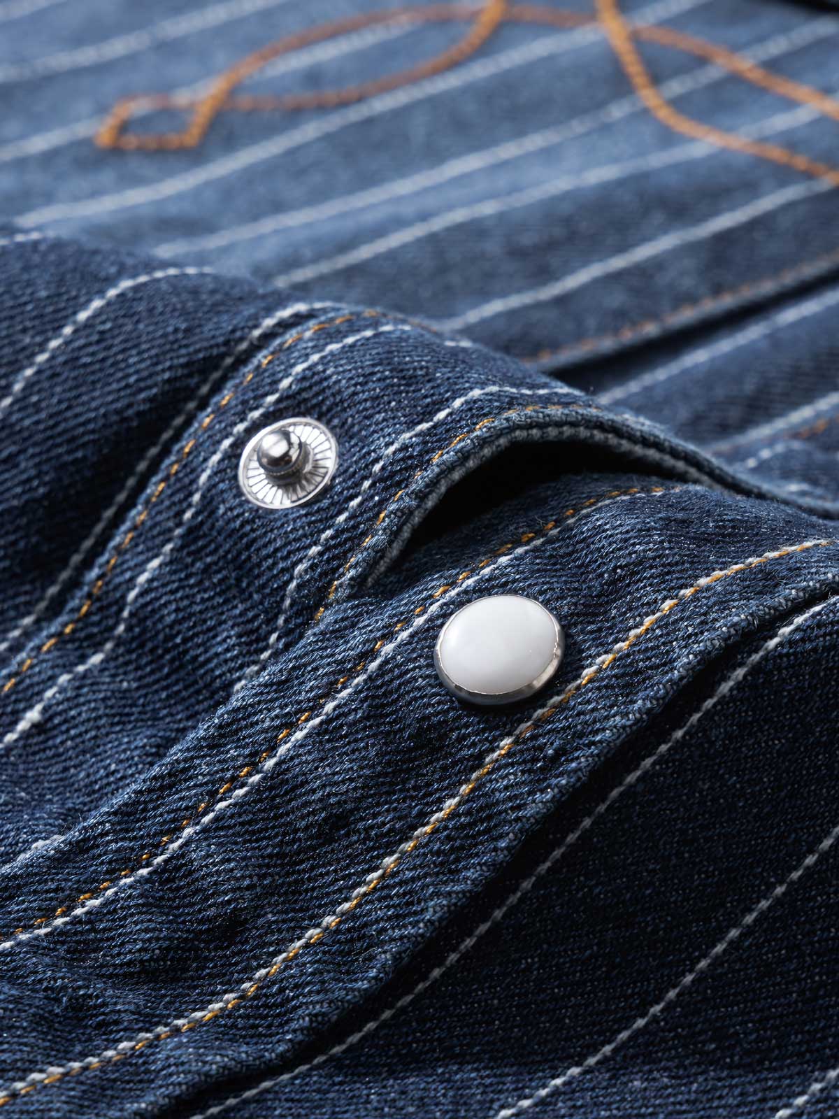 シャツの模造パールボタンと色落ちしたストライプディテールの画像