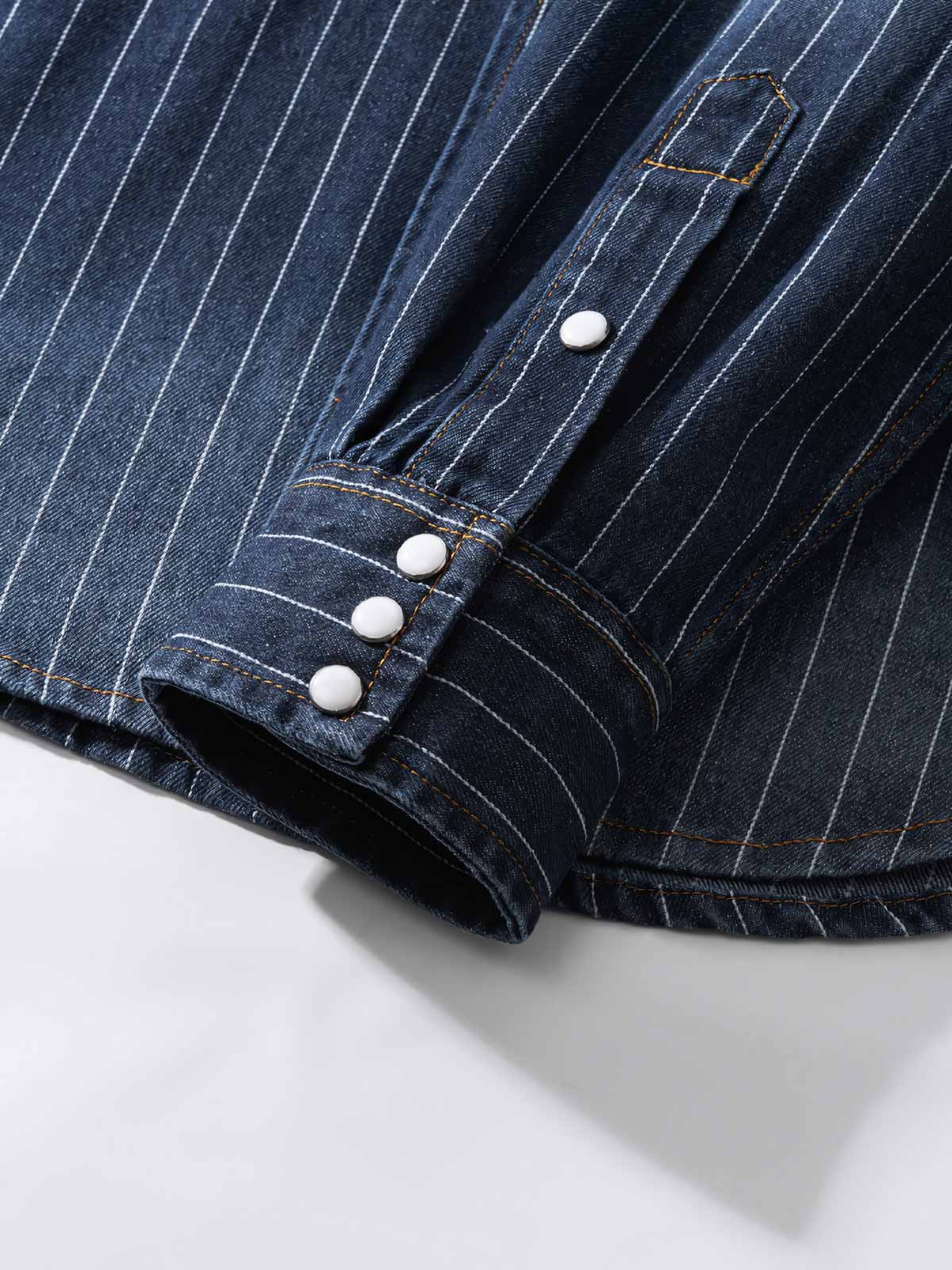 シャツの模造パールボタンと色落ちしたストライプディテールの画像