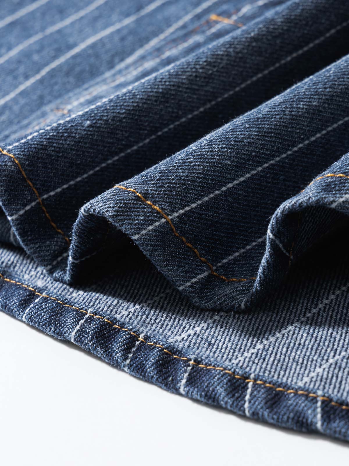 シャツの模造パールボタンと色落ちしたストライプディテールの画像