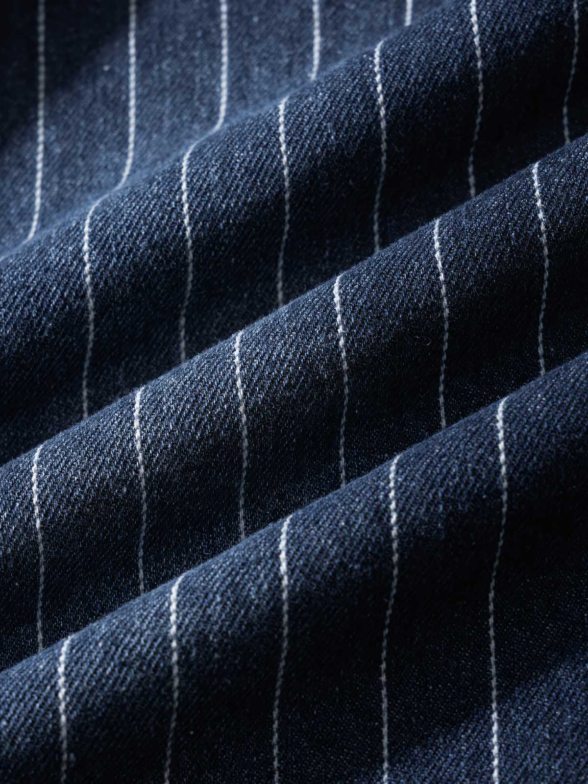 シャツの模造パールボタンと色落ちしたストライプディテールの画像