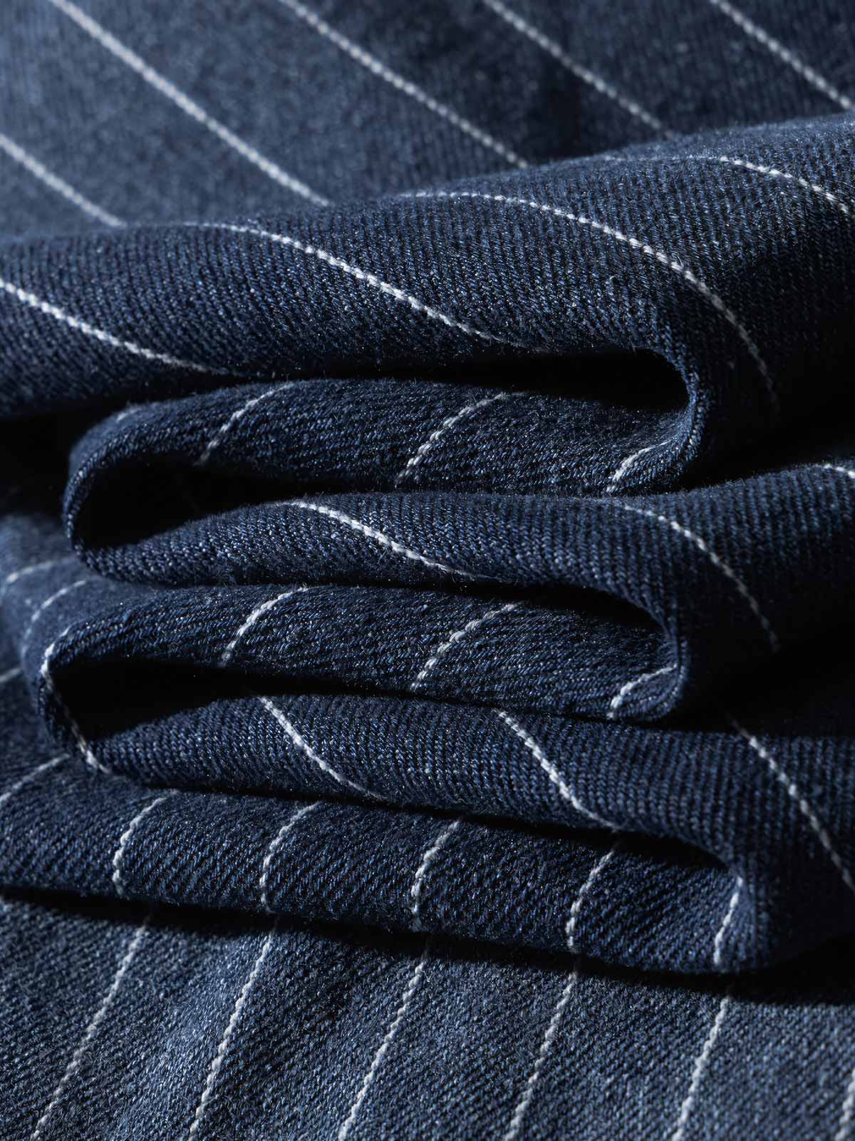 シャツの模造パールボタンと色落ちしたストライプディテールの画像