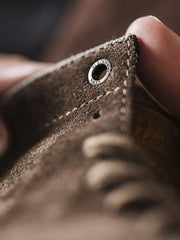 製品画像:
1960年代のマーチンブーツをインスパイアしたワイルドライフ風ダークブラウンスエード作業靴。ダークブラウンのスエードレザーとキャンバス素材を組み合わせ、自然な風合いと耐久性を提供。手縫いのマークスティッチやアクセントカラーのイヤータブがディテールにこだわりを感じさせます。
詳細画像:
ダークブラウンスエードレザーの靴に、耐久性を高める洗い加工したキャンバスを使用。しっかりとした靴筒と履き口のデザイン、手縫いのマークスティッチ、上部の牛革タグが特徴。