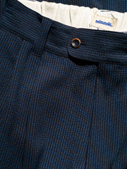 パンツのウエストデザイン、前後のセンターシーム、後部のボタン付きダブルポケットのディテール。