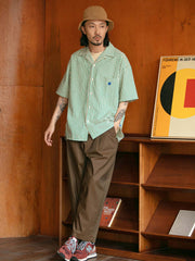 モデルがレトロ縦縞色織りシアサッカー半袖シャツを着用している日常シーンの画像