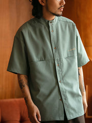 モデルがスクエアポケットエンブロイダリー半袖シャツを着用し、カジュアルパンツと革靴を合わせた全体のスタイル。