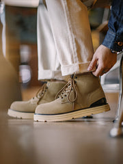 製品画像: 厳選された牛革スエードと特注厚底デザインを組み合わせたヴィンテージ感漂うワークブーツ全体像、グラベルカラーのトーンが特徴。
詳細画像: 牛革スエードのアッパー、PUレザー靴舌、白いステッチが際立つラバーディテールのクローズアップ。