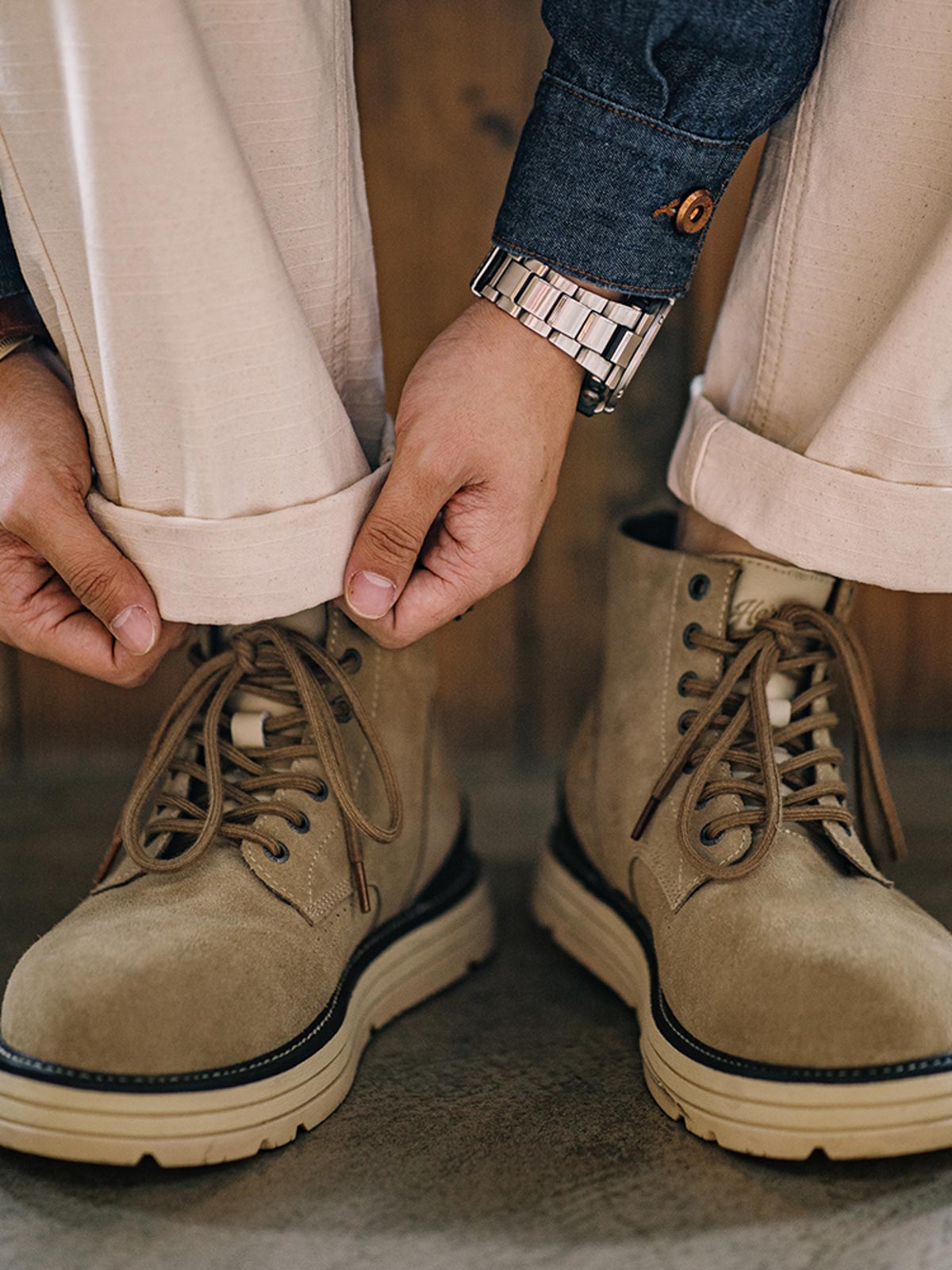 詳細画像: 牛革スエードのアッパー、PUレザー靴舌、白いステッチが際立つラバーディテールのクローズアップ。
モデル画像: モデル着用のヴィンテージスタイルワークブーツ、特注厚底デザインが映えるアウトドアスタイリング例。