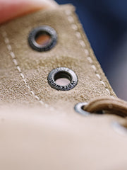 製品画像: 厳選された牛革スエードと特注厚底デザインを組み合わせたヴィンテージ感漂うワークブーツ全体像、グラベルカラーのトーンが特徴。
詳細画像: 牛革スエードのアッパー、PUレザー靴舌、白いステッチが際立つラバーディテールのクローズアップ。