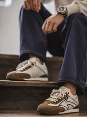 詳細画像: 60Sピースバスケットシューズのアッパー部分、長毛感のあるスエード革と異素材のコンビネーションが美しく融合し、レトロ感を強調しています。金色のレトロ金属刻印と刺繍のディテールがシューズに高級感を与えています。
モデル画像: モデルが60Sピースバスケットシューズを着用している画像。レトロなデザインと現代的な改良が調和したシューズが、クラシックでありながらも個性的なスタイルを演出し、日常のコーディネートにぴったりです。