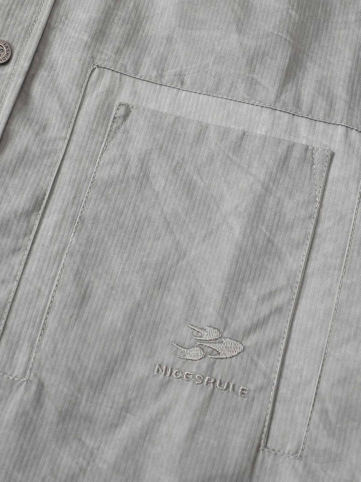 製品画像
「スプレー加工 長袖シャツの正面全体図。20世紀中期のワークウェアやミリタリースタイルから着想を得たデザインで、クラシックなスプレー加工と高密度コットンツイル素材が特徴。ヴィンテージ感と耐久性を兼ね備えたスタイリッシュな一着。」
詳細画像
「スプレー加工 長袖シャツの手作業によるスプレー加工模様とライトなバイオウォッシュ加工のクローズアップ。長年着込んだようなヴィンテージライクな質感を演出する、奥行きのあるテクスチャーと自然な風合いが特徴。」