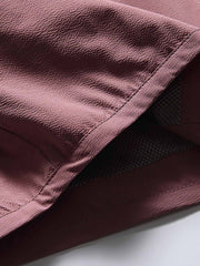 製品画像: フード付きアウトドア機能ベストの正面ビュー、軽量でシンプルなデザインが特徴。アウトドアにもカジュアルにも使えるアイテム。
詳細画像: フードと大きなポケット、防風・防水設計が強調されたディテールショット。耐久性のあるポリエステル素材が確認できる。