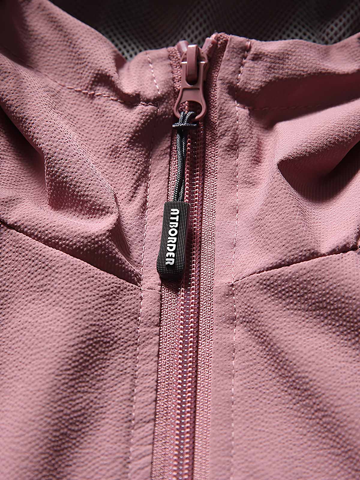 製品画像: フード付きアウトドア機能ベストの正面ビュー、軽量でシンプルなデザインが特徴。アウトドアにもカジュアルにも使えるアイテム。
詳細画像: フードと大きなポケット、防風・防水設計が強調されたディテールショット。耐久性のあるポリエステル素材が確認できる。