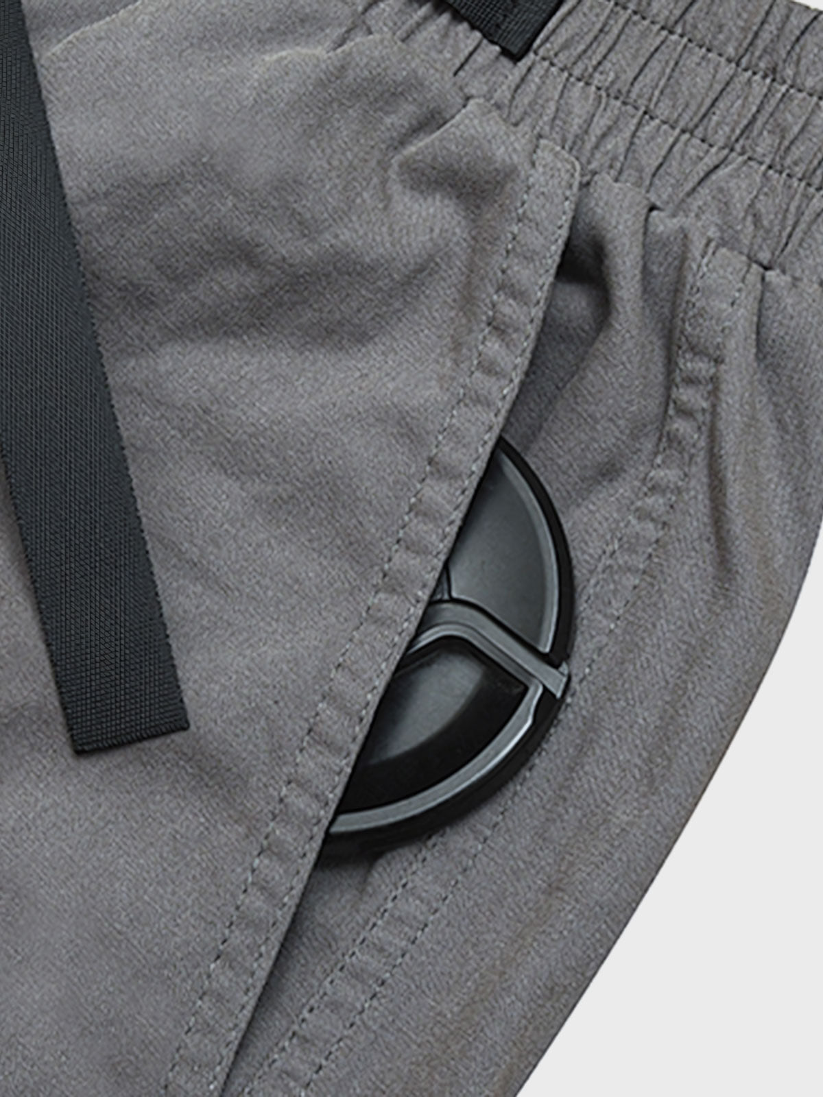 カジュアルパンツのドローコードとパッチワークディテールのクローズアップ。素材の耐久性と細部の工夫が見て取れる、機能的でスタイリッシュなデザイン。