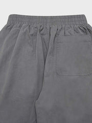 カジュアルパンツのドローコードとパッチワークディテールのクローズアップ。素材の耐久性と細部の工夫が見て取れる、機能的でスタイリッシュなデザイン。