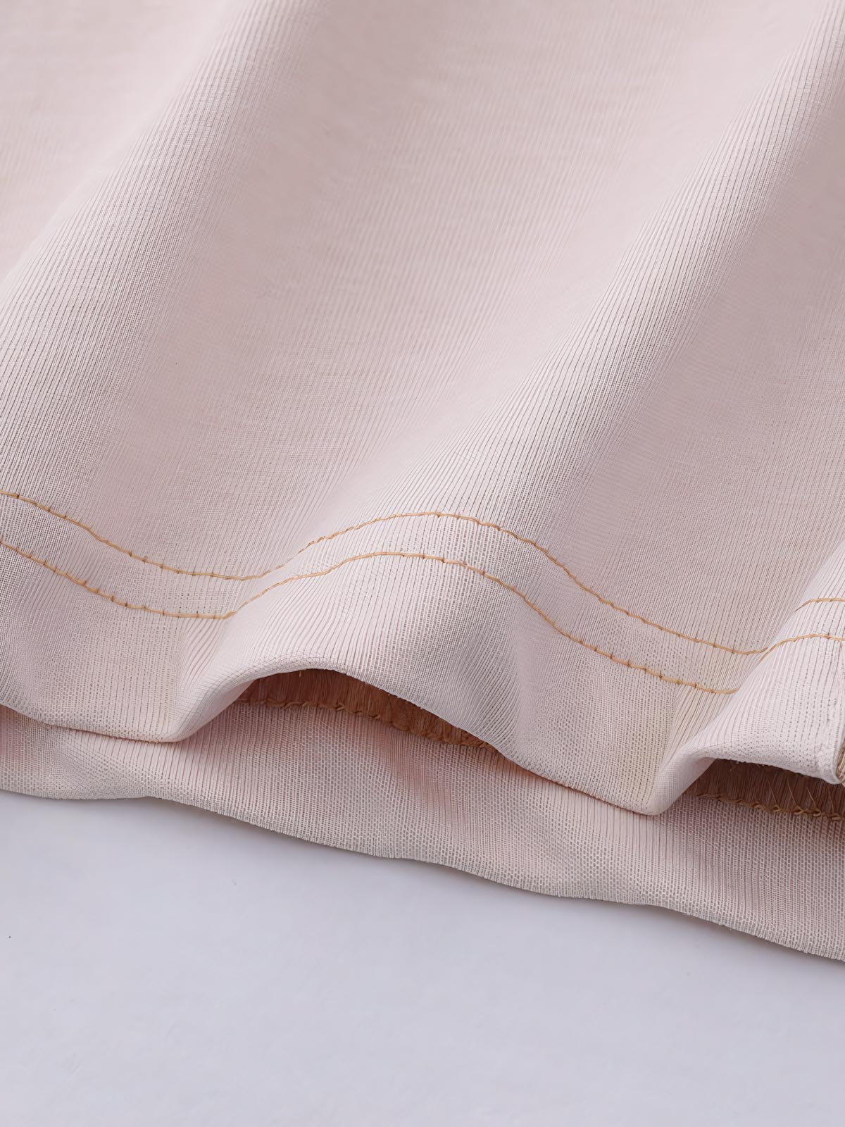 ポロシャツのバイカラーパネルと胸元の刺繍ロゴのディテール特写