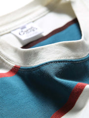 純綿素材のブルー&ホワイトストライプTシャツのクローズアップ。通気性と吸湿性に優れ、胸元のアルファベットプリントが洗練されたデザインアクセントを提供