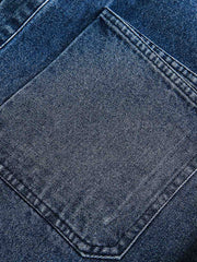 デニム半袖シャツの細部のクローズアップ、精巧なステッチとクラシックなボタンが見える。質感が豊かで、着用するほどに個性が現れる高品質デニム生地が特徴。