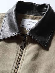 製品画像: レザーカラーワークジャケットの正面展示
詳細画像: ジャケットのレザー襟とジップポケットのディテール展示