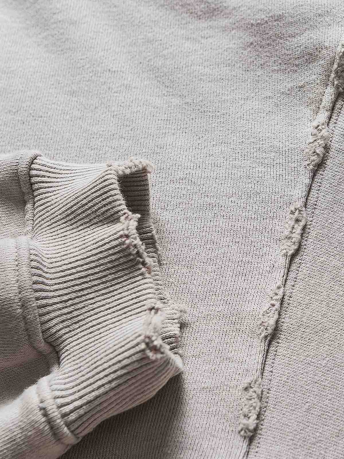 製品画像: ヴィンテージ風ダメージ加工とトレンドプリントが特徴のコットン100%ルーズフィットパーカー、ストリートスタイルに最適なフロント平置き画像
詳細画像: ダメージ加工とプリントデザインのディテール特写、カジュアルなスタイリングにおすすめ