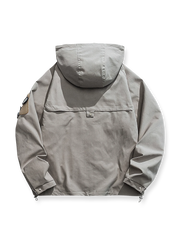 製品画像: エポレット付きフードワークジャケットの正面展示。ミリタリー風デザインと実用性を兼ね備え、防風・防水機能でアウトドアにも最適。エポレットと多機能パッチが特徴的。
詳細画像: エポレットディテールと袖口のパッチ、ドローコード付き裾の調整可能なデザインが際立つ。軽量で着やすい100%ポリエステル素材が防風・防水機能を提供。