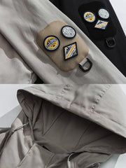 製品画像: エポレット付きフードワークジャケットの正面展示。ミリタリー風デザインと実用性を兼ね備え、防風・防水機能でアウトドアにも最適。エポレットと多機能パッチが特徴的。
詳細画像: エポレットディテールと袖口のパッチ、ドローコード付き裾の調整可能なデザインが際立つ。軽量で着やすい100%ポリエステル素材が防風・防水機能を提供。