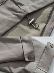 製品画像: エポレット付きフードワークジャケットの正面展示。ミリタリー風デザインと実用性を兼ね備え、防風・防水機能でアウトドアにも最適。エポレットと多機能パッチが特徴的。
詳細画像: エポレットディテールと袖口のパッチ、ドローコード付き裾の調整可能なデザインが際立つ。軽量で着やすい100%ポリエステル素材が防風・防水機能を提供。