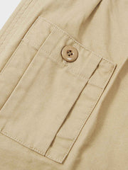 パンツの調整ストラップとポケットのディテールをクローズアップで表示し、その機能性と耐久性のある素材を強調。