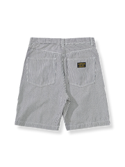 レールロードストライプデニムショートパンツの全体像を展示し、そのユニークなデザインと色合いが強調されています。