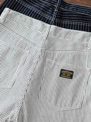 デニムショートパンツの鉄道ストライプパターンと強化されたポケットの詳細をクローズアップ。