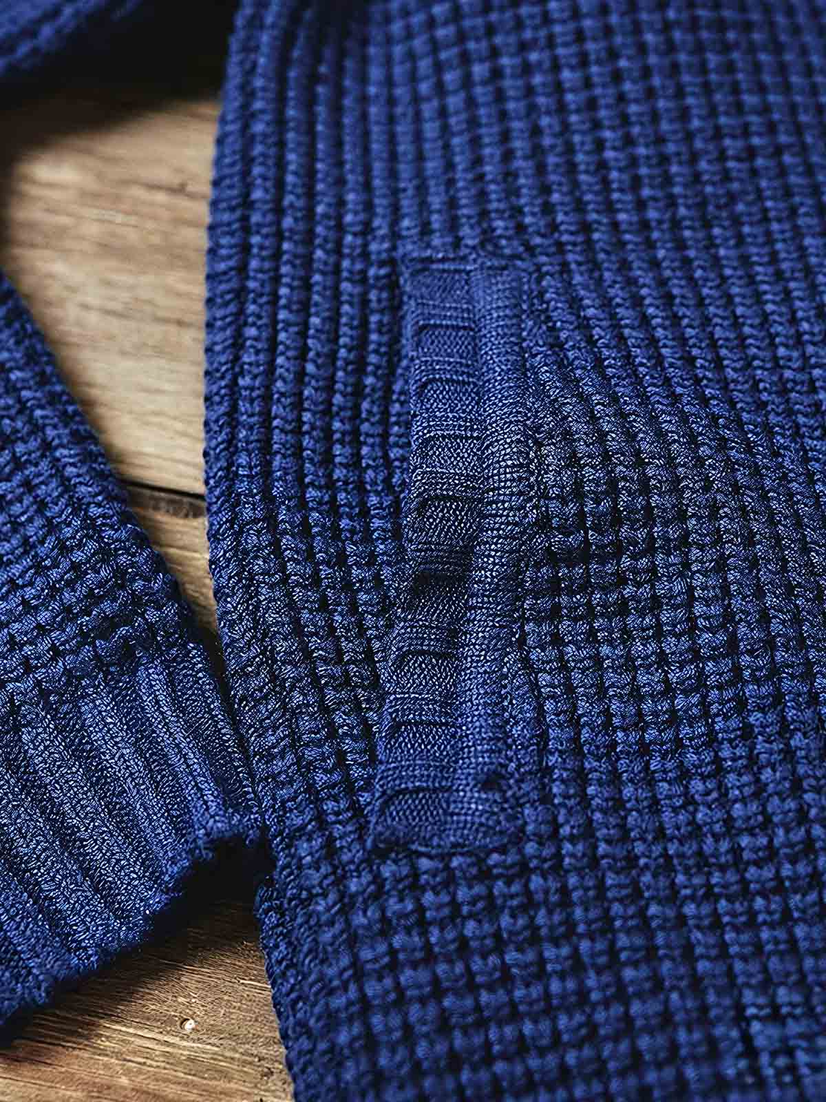 製品画像:
「ラウンドカラー ウール混紡 カーディガンの全体正面展示図。クラシックなワッフル柄デザインとウール65%混紡素材が特徴で、保温性とヴィンテージ感を兼ね備えた冬の定番アイテム。」
詳細画像:
「ラウンドカラー ウール混紡 カーディガンのワッフル柄ディテールとジャカード織り縁部分のクローズアップ。立体感のある柄と丁寧な縁加工が、全体の質感とデザイン性を引き立てます。」