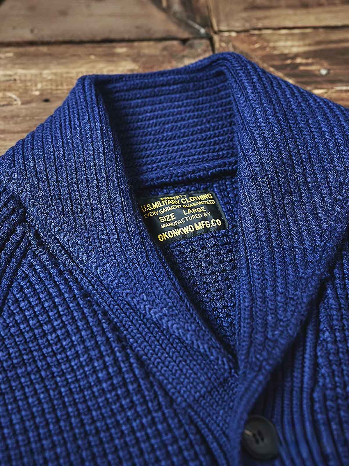 製品画像:
「ラウンドカラー ウール混紡 カーディガンの全体正面展示図。クラシックなワッフル柄デザインとウール65%混紡素材が特徴で、保温性とヴィンテージ感を兼ね備えた冬の定番アイテム。」
詳細画像:
「ラウンドカラー ウール混紡 カーディガンのワッフル柄ディテールとジャカード織り縁部分のクローズアップ。立体感のある柄と丁寧な縁加工が、全体の質感とデザイン性を引き立てます。」