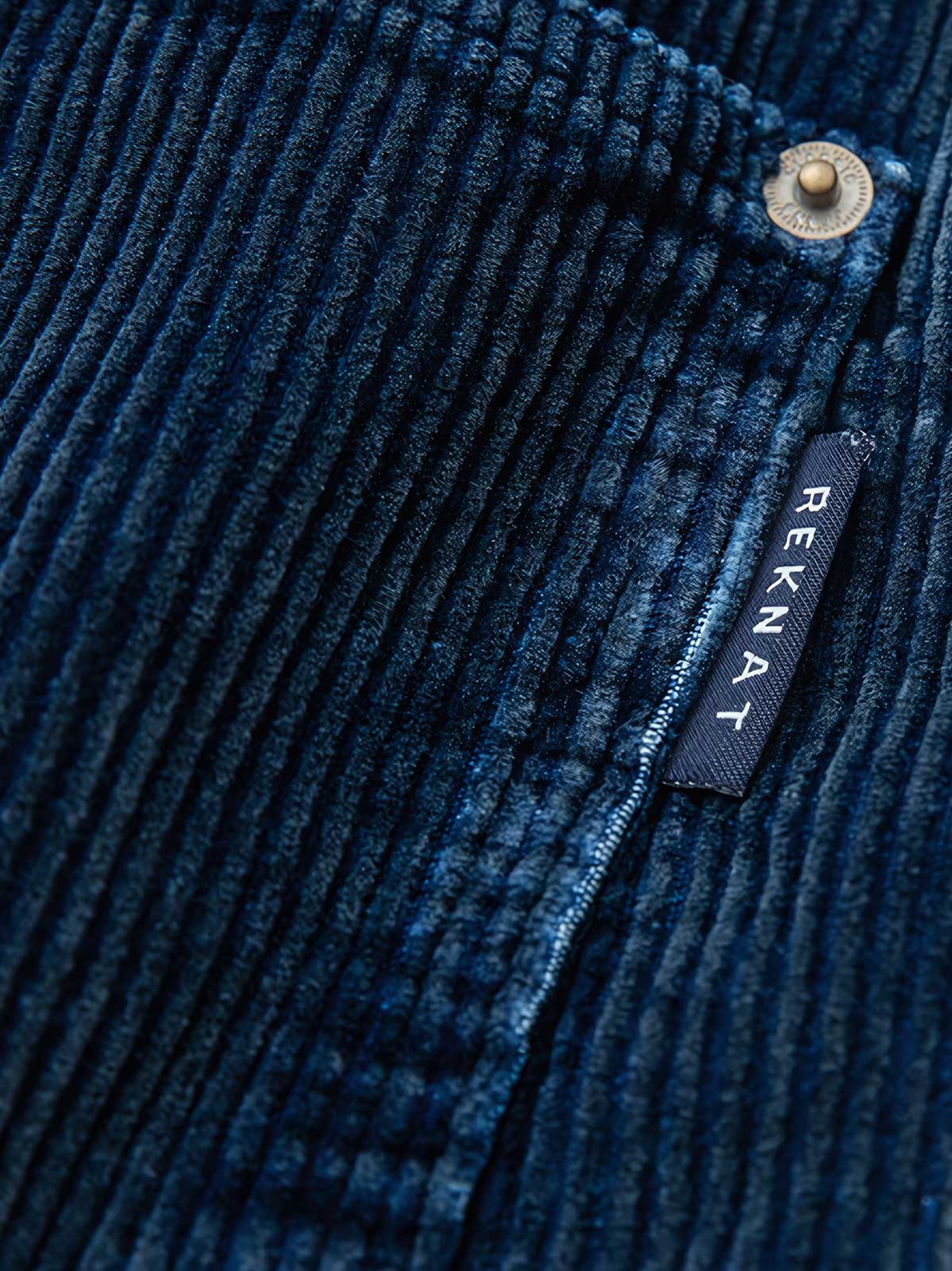 製品画像:
"水洗ヴィンテージ加工を施したデニムブルーの粗畝コーデュロイワークパンツ、秋冬シーズンにぴったりな重厚感のある素材とレトロな雰囲気が特徴の全体図"
詳細画像:
"粗畝コーデュロイ素材の肌理感とドローストリング仕様のウエスト部分をクローズアップした画像、ヴィンテージ加工による深みのあるデニムブルーが際立つディテール"