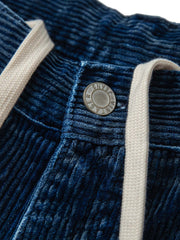 製品画像:
"水洗ヴィンテージ加工を施したデニムブルーの粗畝コーデュロイワークパンツ、秋冬シーズンにぴったりな重厚感のある素材とレトロな雰囲気が特徴の全体図"
詳細画像:
"粗畝コーデュロイ素材の肌理感とドローストリング仕様のウエスト部分をクローズアップした画像、ヴィンテージ加工による深みのあるデニムブルーが際立つディテール"