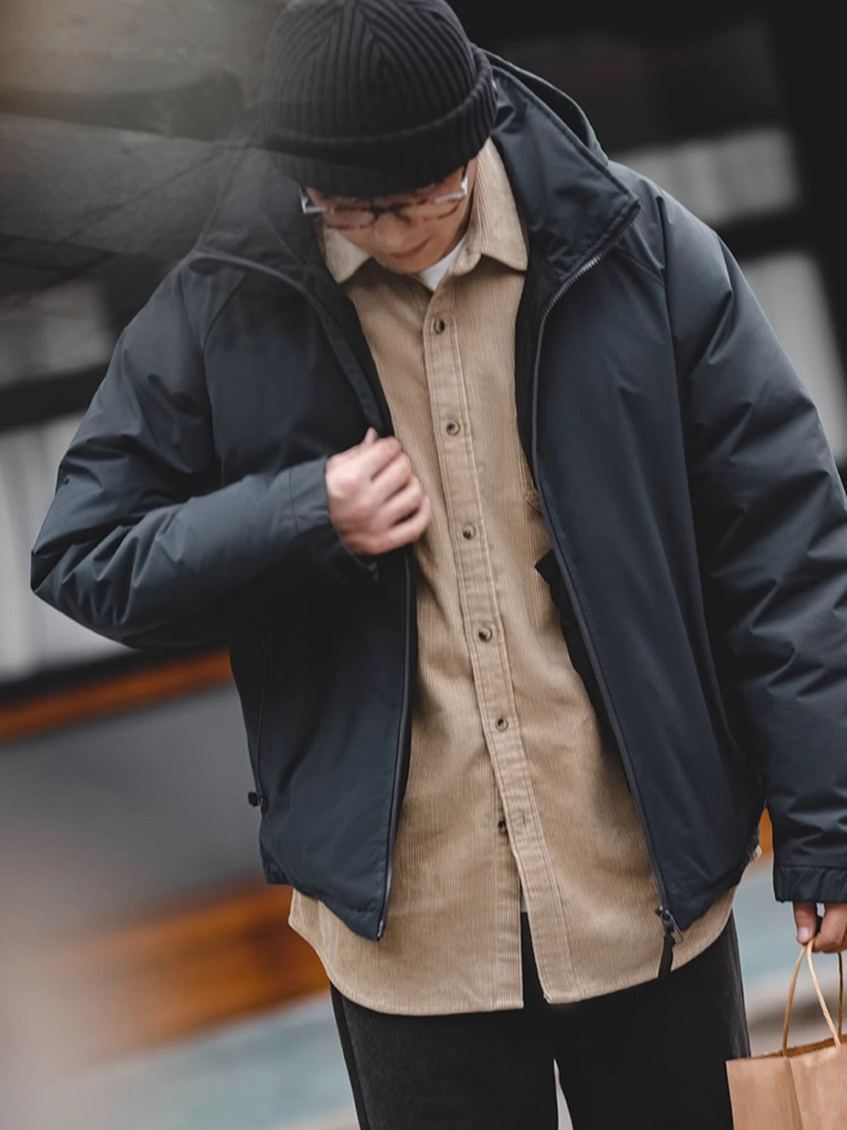 詳細画像
マットな光沢のナイロン生地、取り外し可能な防風フード、裾のエラスティックドローコードが実用性を高め、寒風を防ぎます。多層構造でダウンの膨らみを保ちつつ、優れた保温性を発揮します。シンプルでスリムなラインが特徴。
モデル画像
ECWCS L7スタイルのフード付きダウンジャケットを着用したモデル、冬の寒さにも対応できる優れた保温性とスタイリッシュなデザインが際立つ。