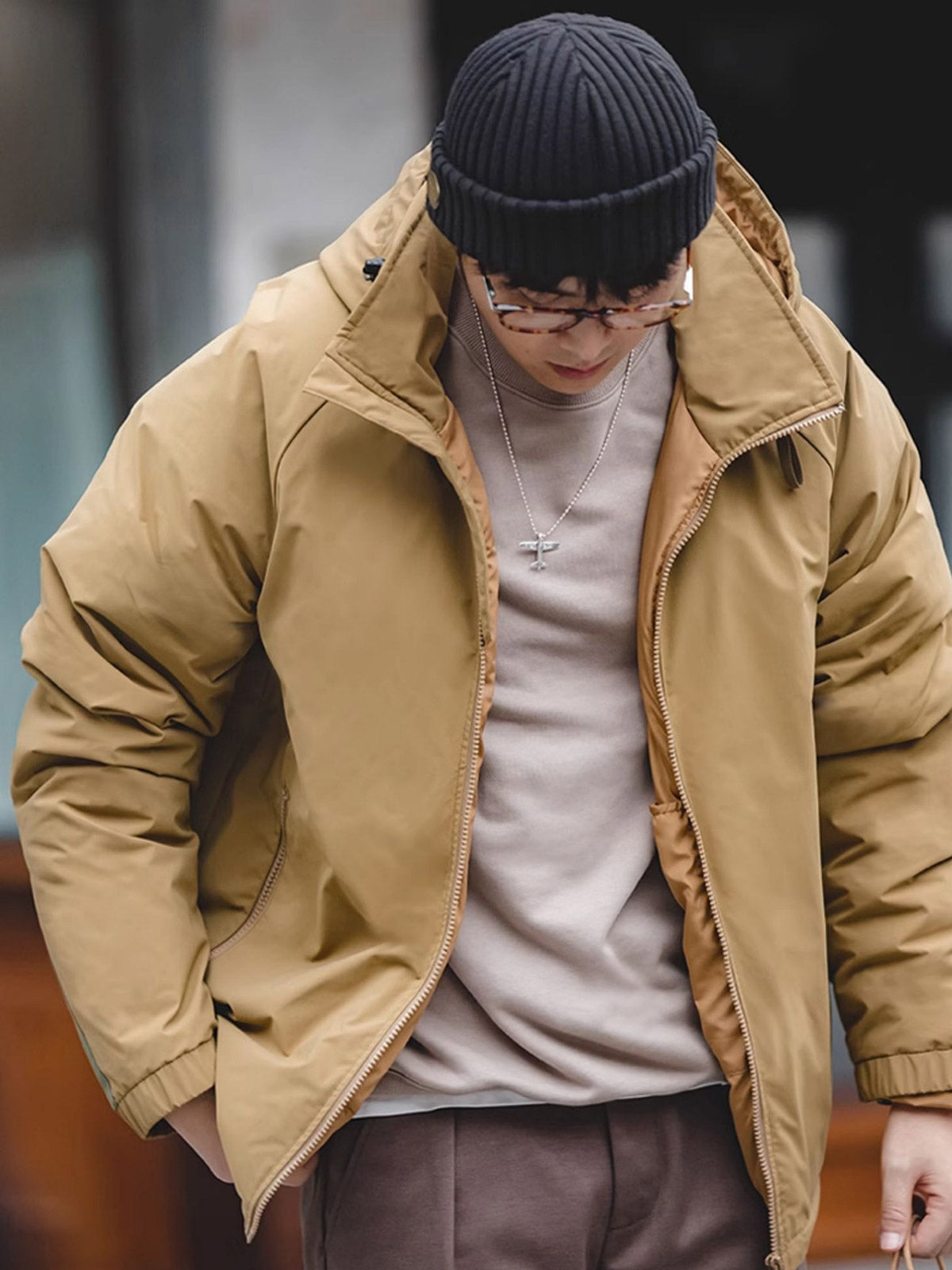 詳細画像
マットな光沢のナイロン生地、取り外し可能な防風フード、裾のエラスティックドローコードが実用性を高め、寒風を防ぎます。多層構造でダウンの膨らみを保ちつつ、優れた保温性を発揮します。シンプルでスリムなラインが特徴。
モデル画像
ECWCS L7スタイルのフード付きダウンジャケットを着用したモデル、冬の寒さにも対応できる優れた保温性とスタイリッシュなデザインが際立つ。