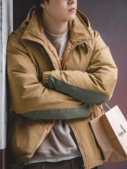 詳細画像
マットな光沢のナイロン生地、取り外し可能な防風フード、裾のエラスティックドローコードが実用性を高め、寒風を防ぎます。多層構造でダウンの膨らみを保ちつつ、優れた保温性を発揮します。シンプルでスリムなラインが特徴。
モデル画像
ECWCS L7スタイルのフード付きダウンジャケットを着用したモデル、冬の寒さにも対応できる優れた保温性とスタイリッシュなデザインが際立つ。